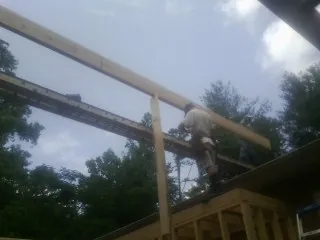 Carpenter setting a ridge beam over a new addition frame — Ice Dam Removal by Roofing Brothers in Trafalgar